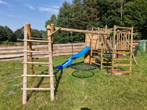 a wooden playground with a swing and a ladder at Przystanek Przywidz in Trzepowo