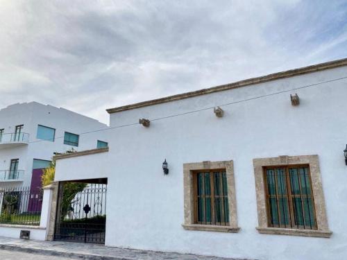 a white building with two windows on the side of it at Casita Nodin in Cuatrociénegas de Carranza