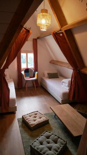 a bedroom with two beds and a table and a chair at Surf Hostel Quiberon, L'Oyat in Saint-Pierre-Quiberon