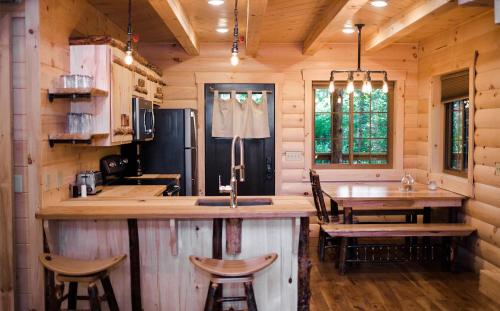 una cocina con barra y una mesa en una cabaña en Treehouse #1 by Amish Country Lodging, en Millersburg