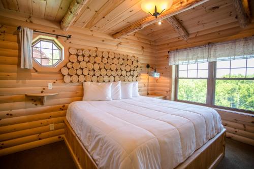 1 dormitorio con 1 cama grande en una cabaña de madera en Red Fern Cabin by Amish Country Lodging, en Berlin