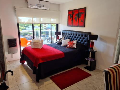 a bedroom with a bed with a red blanket at Acogedor monoambiente La Plata centro in La Plata