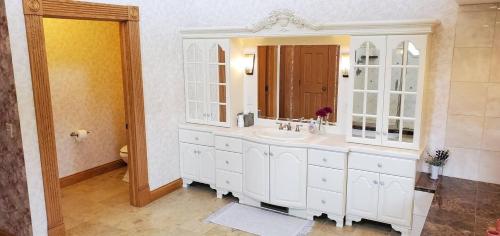 a white bathroom with a sink and a mirror at Victorian Suite by Amish Country Lodging in Millersburg