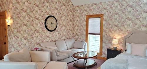 a living room with a couch and a bed and a clock at Victorian Suite by Amish Country Lodging in Millersburg