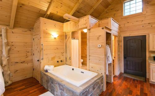 uma grande casa de banho com banheira numa casa de madeira em Whispering Pines Treehouse by Amish Country Lodging em Millersburg