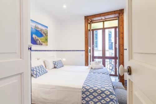 a white bedroom with a bed and a window at Can Boss - Turismo de Interior in Palma de Mallorca