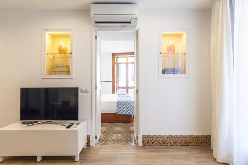a living room with a flat screen tv and a white cabinet at Can Boss - Turismo de Interior in Palma de Mallorca