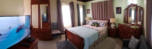1 dormitorio con 1 cama y baño con bañera en Irie HideAway - Private Studio in Gated Community --Caribbean Estates, Portmore, en Goshen Pen