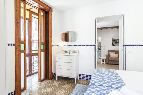 a bedroom with a bed and a door to a living room at Can Boss - Turismo de Interior in Palma de Mallorca