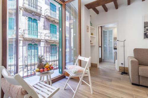 a living room with a table and chairs and a window at Can Boss - Turismo de Interior in Palma de Mallorca