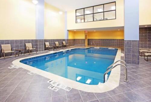 a pool in the middle of a building with chairs at Holiday Inn Express & Suites Niagara Falls, an IHG Hotel in Niagara Falls