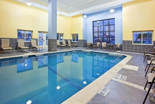 a large swimming pool with chairs and tables at Holiday Inn Express & Suites Niagara Falls, an IHG Hotel in Niagara Falls