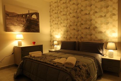 a bedroom with a large bed with two night stands and two lamps at B&B Acquedotto in Corigliano Calabro