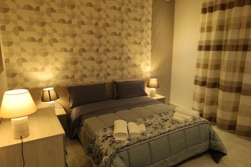 a bedroom with a bed and two tables and two lamps at B&B Acquedotto in Corigliano Calabro