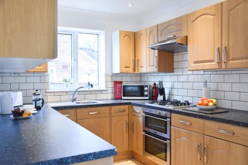 a kitchen with wooden cabinets and a counter top at Stafford House in Norwich