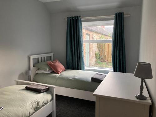 una piccola camera da letto con due letti e una finestra di Charleton Farm Cottages a Montrose