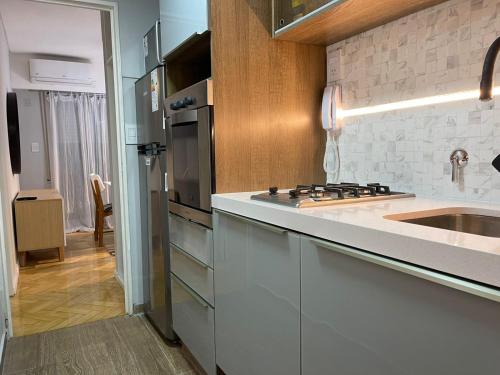 uma cozinha branca com um lavatório e um fogão em Departamento Fabuloso em Rosário
