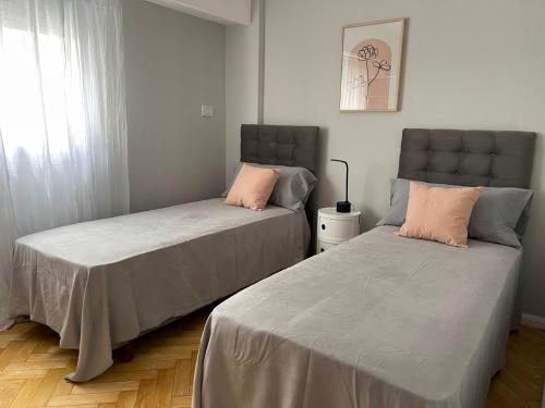 twee bedden naast elkaar in een slaapkamer bij Departamento Fabuloso in Rosario