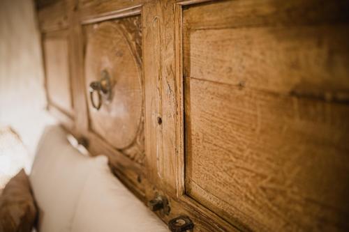 a wooden dresser with a wooden door on a bed at Moon's Tower suite&rooms in Portoscuso