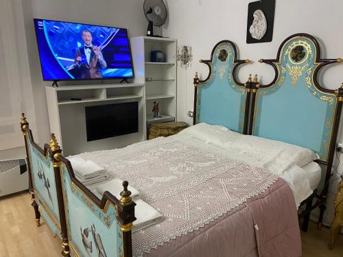 Schlafzimmer mit einem Bett und einem Flachbild-TV in der Unterkunft appartamento perugia in Perugia