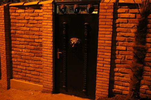 a black door in a brick wall at Apartment Elle2 in Tbilisi City