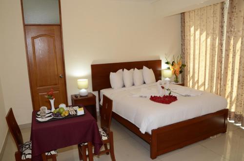a hotel room with a bed and a table with food on it at Aqua Hotel Cusco in Cusco