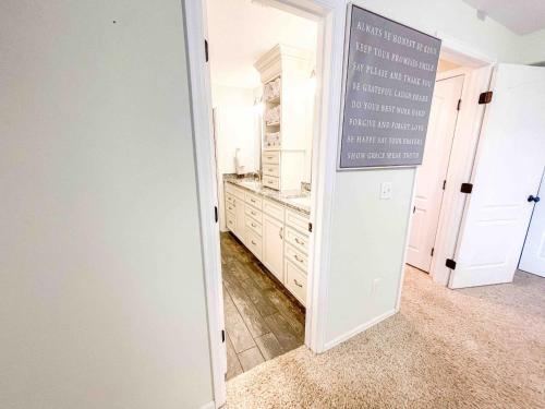 a kitchen with white cabinets and a sign on the door at 2 Master Suites! Pet Friendly With MTN Views in Palmer Lake