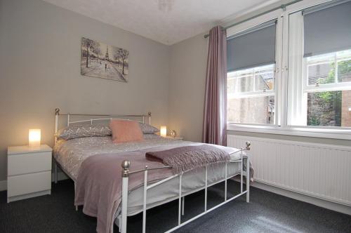 a bedroom with a bed and a large window at Mar Apartment in Stirling