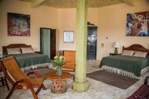 Un dormitorio con 2 camas y una columna con una mesa. en Posada El Castillo xilitla en Xilitla