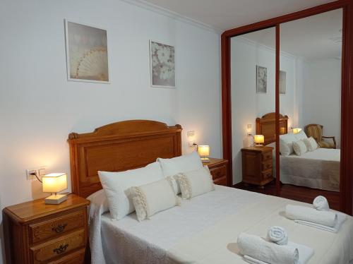 1 dormitorio con 1 cama grande y 2 espejos en Martínez Rooms Pilgrims, en Caldas de Reis
