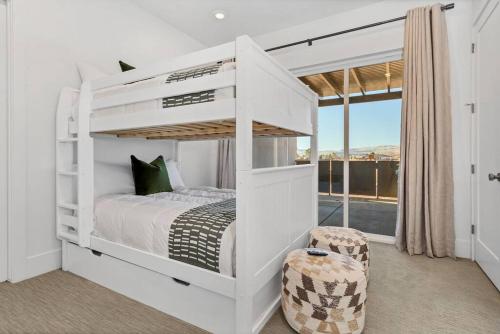 a white bedroom with a bunk bed and a window at Villa 19 - LUXURY GOLF VILLA, BEST VIEW, YEAR ROUND HEATED POOL & HOT TUB! in St. George