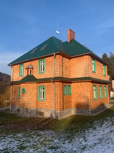 una gran casa de ladrillo con techo verde en Chata Klášter, en Hraběšice
