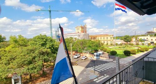 eine Flagge auf einem Balkon mit einem Gebäude in der Unterkunft Circo Hostel in Asunción