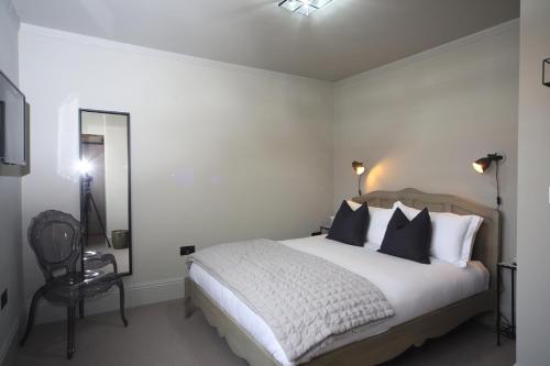 a bedroom with a large bed and a chair at The SOLO No 1 Bank Chambers in Sleaford