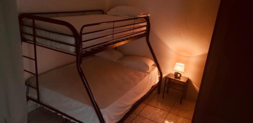 a bunk bed in a small room with a lamp at Colina Buena vista A4 in Jarabacoa