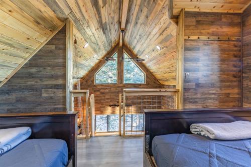 a bedroom with two beds and a large window at RidgeWalk Treehouse in Angel Fire
