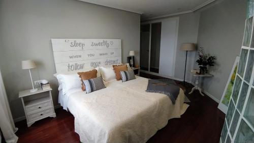 Un dormitorio con una cama grande con almohadas. en APARTAMENTO VISTAZUL SAMIL, en Vigo