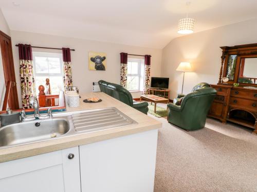 a kitchen with a sink and a living room at Peniarth in Pen-y-bont-fawr