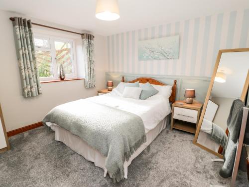 a bedroom with a bed and a mirror at Peniarth in Pen-y-bont-fawr