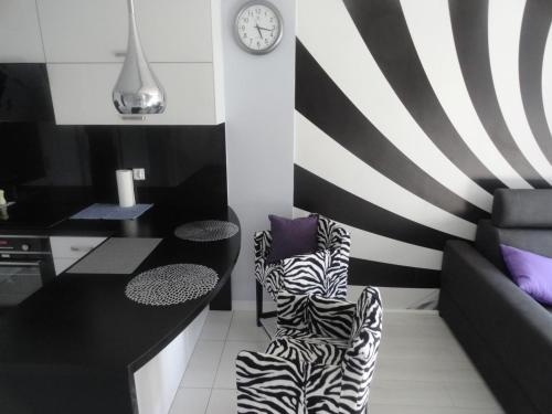 a black and white kitchen with a zebra print chair at Lukusowy apartament dla Pary in Mrągowo