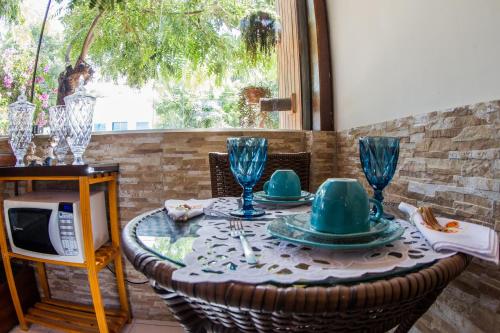 una mesa con platos y vasos encima en Pousada da Leide, en Fernando de Noronha