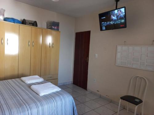um quarto com uma cama e uma televisão na parede em casa a 5 minutos do aeroporto e Univida em Araraquara
