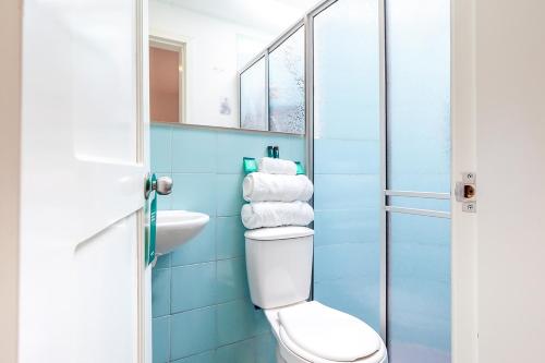 ein Badezimmer mit einem WC, einem Waschbecken und einem Spiegel in der Unterkunft Ayenda Casa La Castellana in Pasto