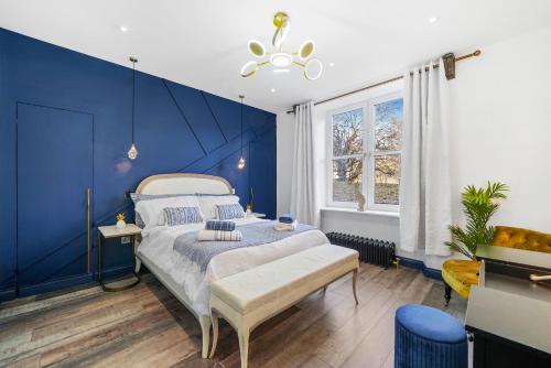 a bedroom with blue walls and a bed with a bench at Roslin Place - Grampian Lettings Ltd in Aberdeen