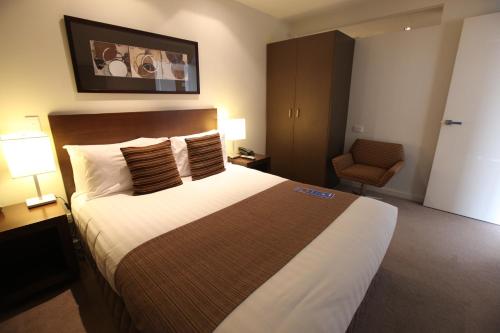 a hotel room with a large bed and a chair at Wyndham Resort Torquay in Torquay