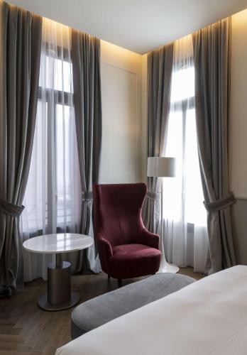 a hotel room with a bed and a chair and window at Radisson Collection Hotel, Palazzo Nani Venice in Venice