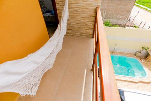 a hammock in a room with a swimming pool at Casa aconchegante em São Miguel dos Milagres-AL in São Miguel dos Milagres