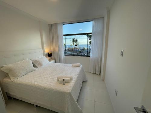 a bedroom with a bed and a large window at SALVADOR Ondina 3 quartos frente praia in Salvador