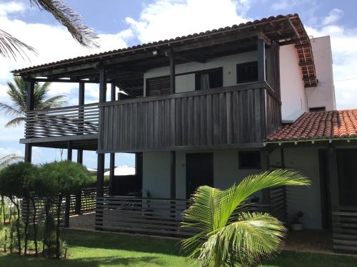 a house with a balcony and a palm tree at Tabatinga Beach Hotel in Nísia Floresta