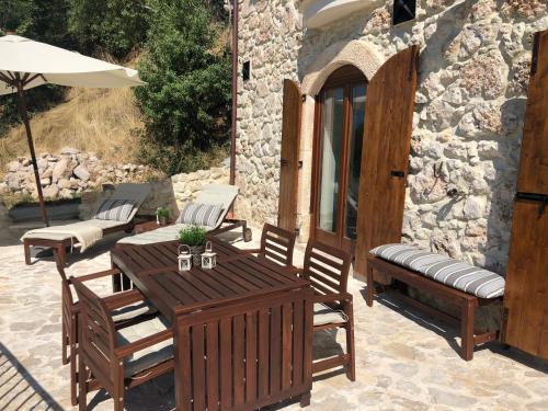 een patio met een tafel en stoelen en een parasol bij Il Terrazzo in Santo Stefano di Sessanio